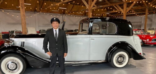 chauffeur standing next to 1938 Rolls Royce Phantom III