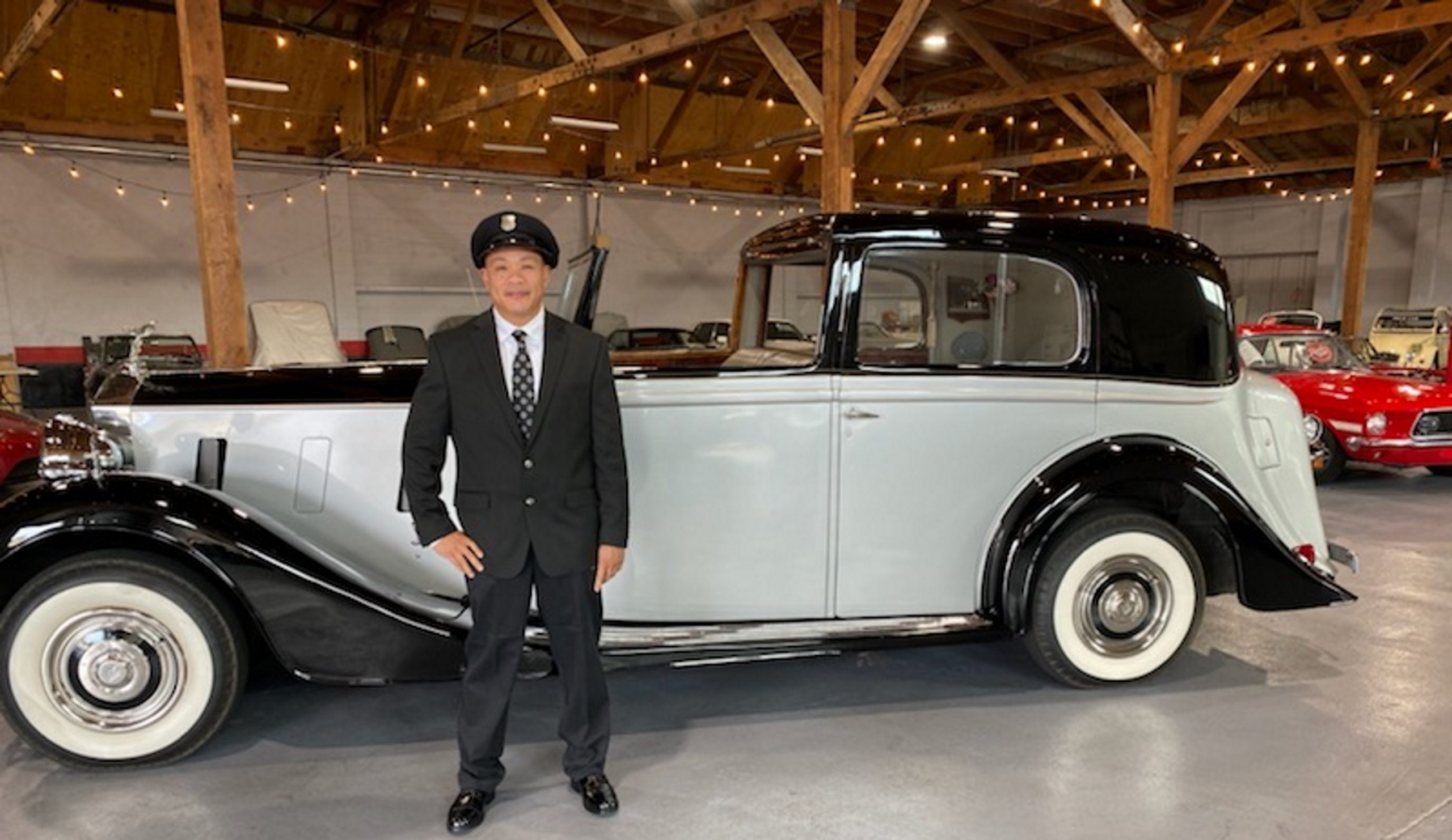 chauffeur standing next to 1938 Rolls Royce Phantom III