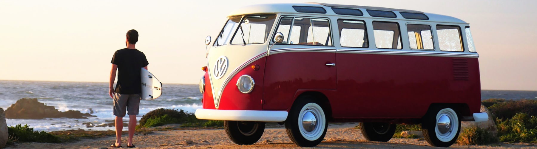 surfer standing next to VW Bus rental