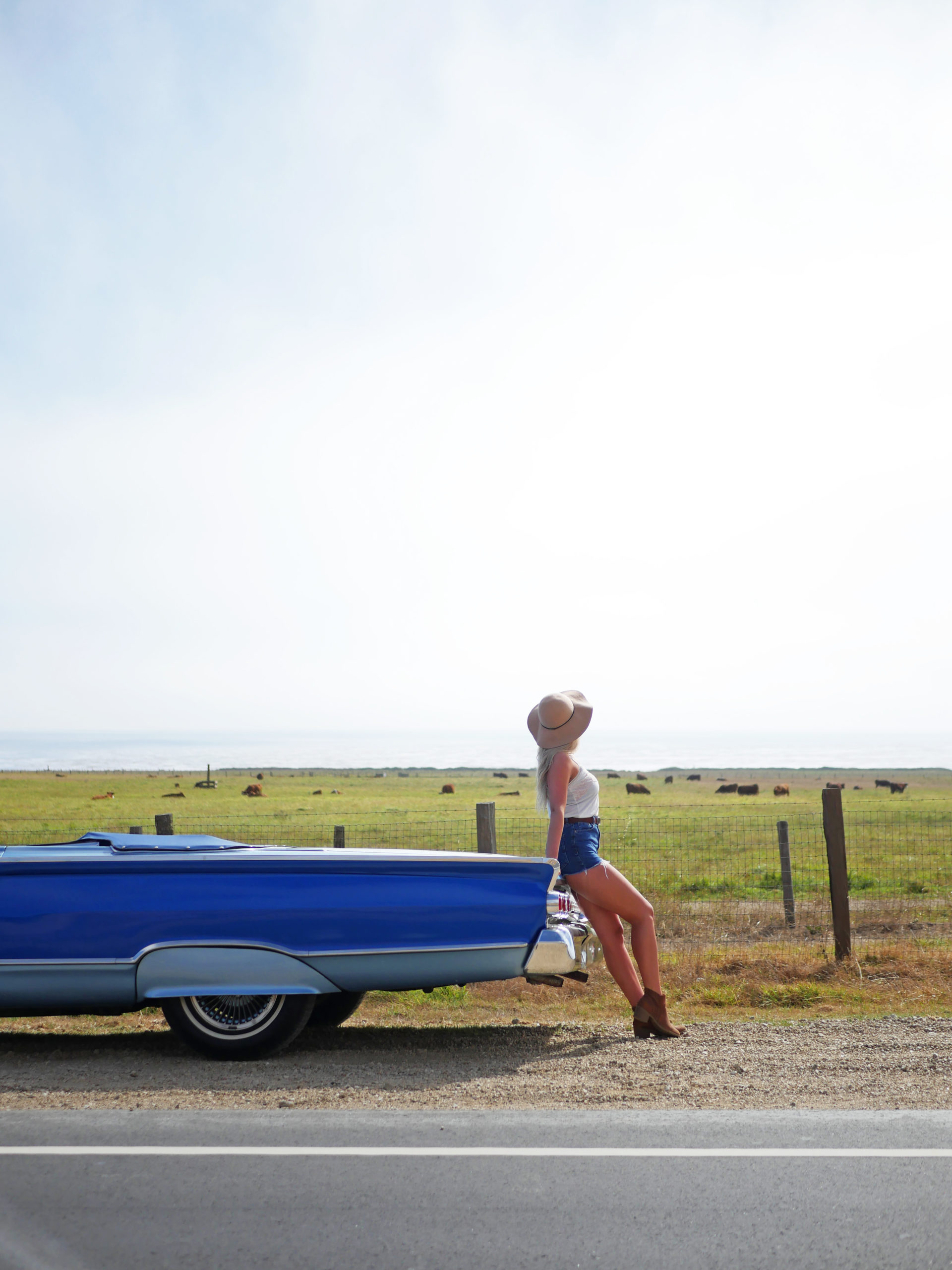 woman leaning on vintage car in big sur