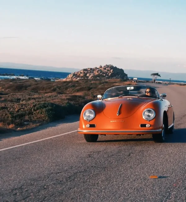 classic car driving along CA coast
