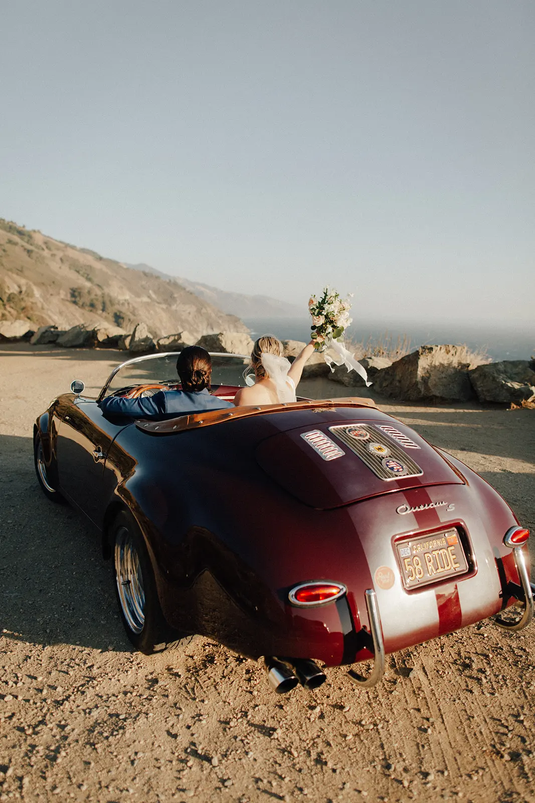married couple celebrating wedding in classic car